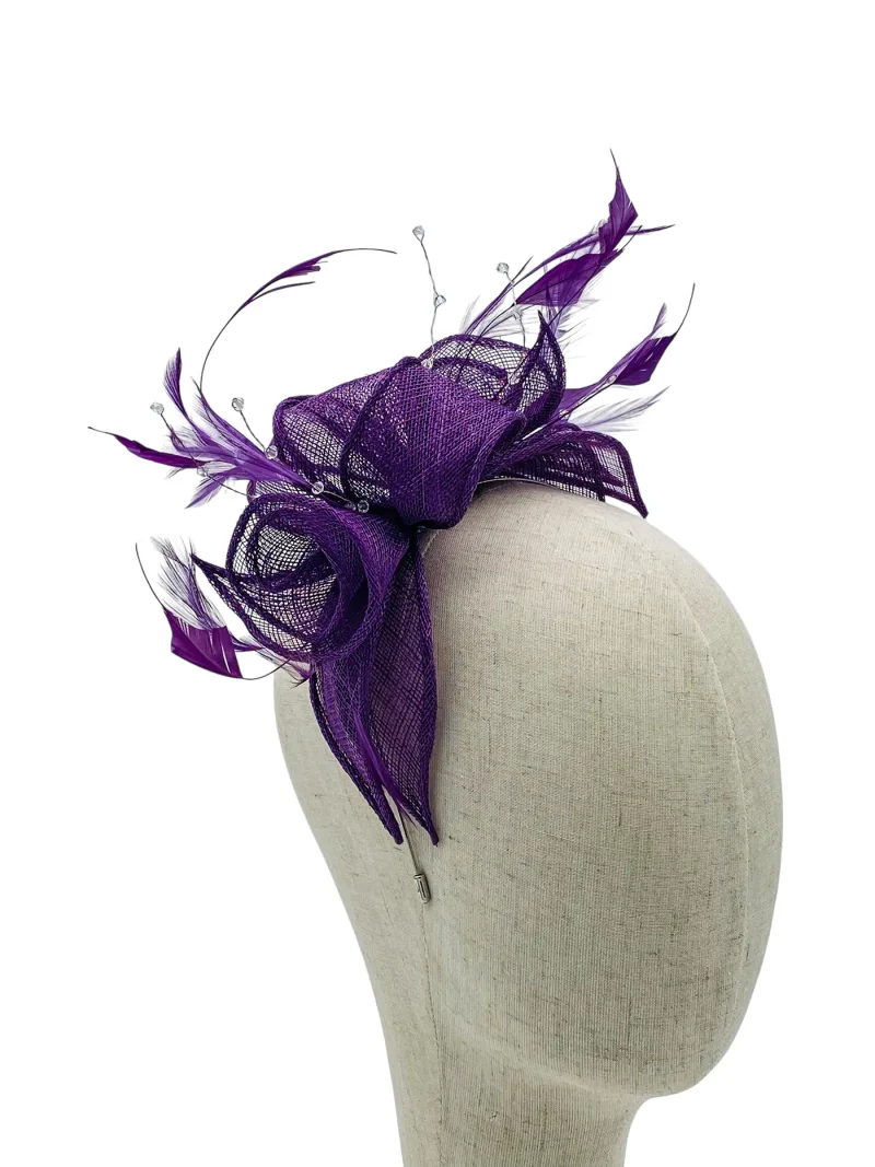 Purple mesh fascinator with feathers on a beige mannequin head / dress form