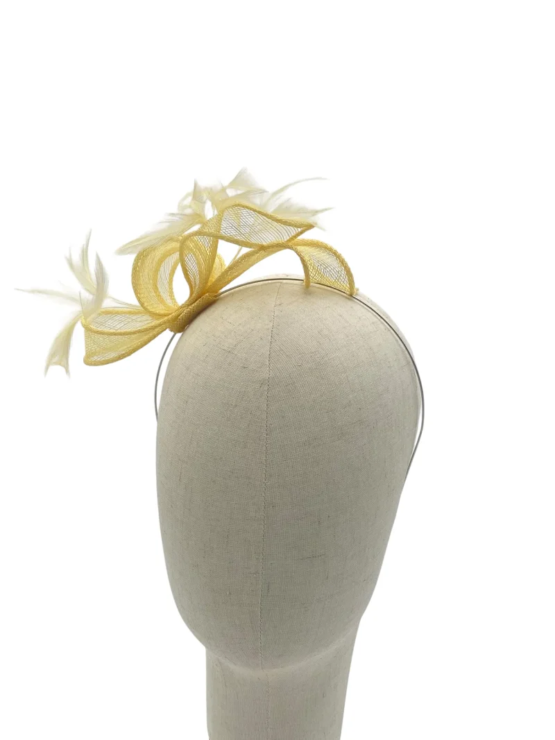 Dainty lemon minimalist sculptural fascinator with twisted sinamay, three-quarter view on a mannequin head