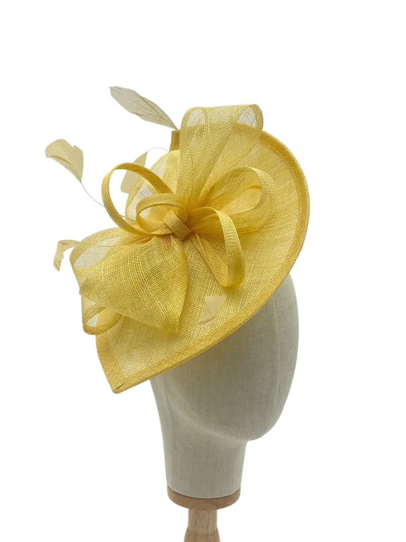 Large lemon modern wedding fascinator with looped detail, angled view on a mannequin head