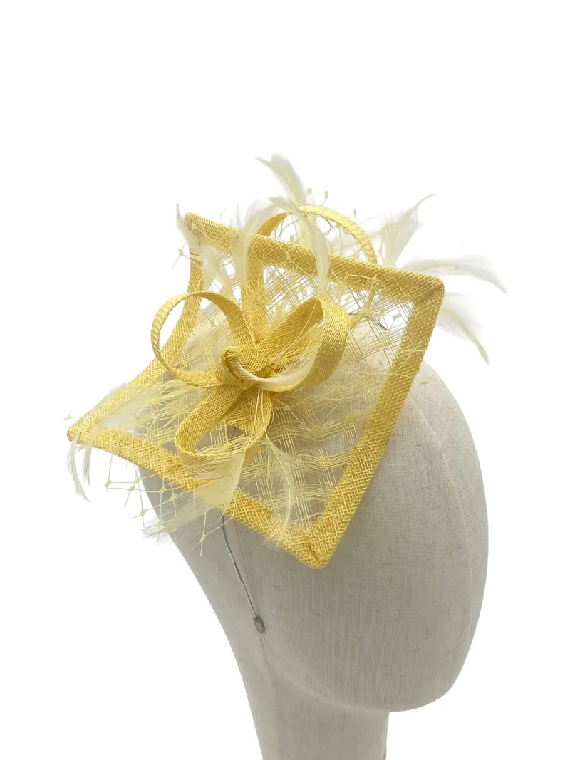 Lemon fascinator for weddings or royal Ascot with square sinamay and feathers, three-quarter view on a mannequin head