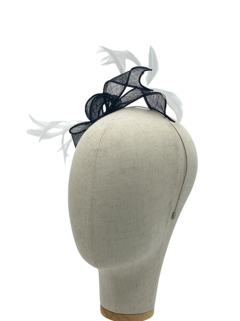 Dainty black and white minimalist sculptural fascinator with looped sinamay and feathers, angled view on a mannequin head