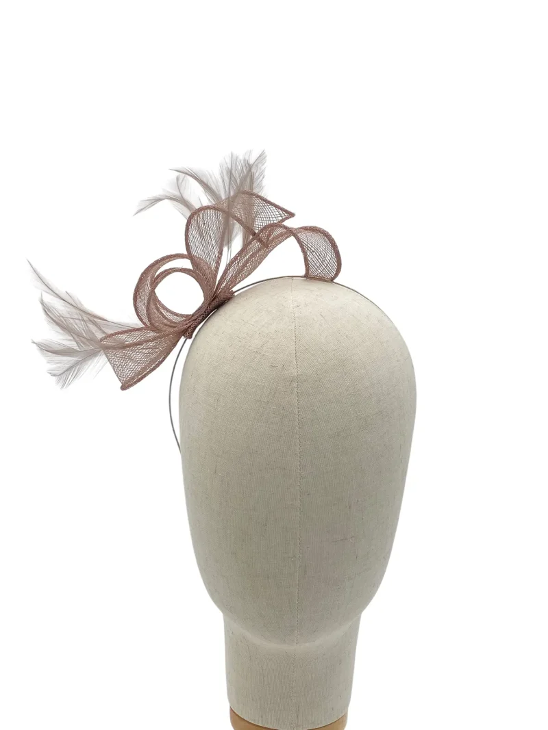 Beige mannequin head wearing a brown mesh bow fascinator with feather accents on the side