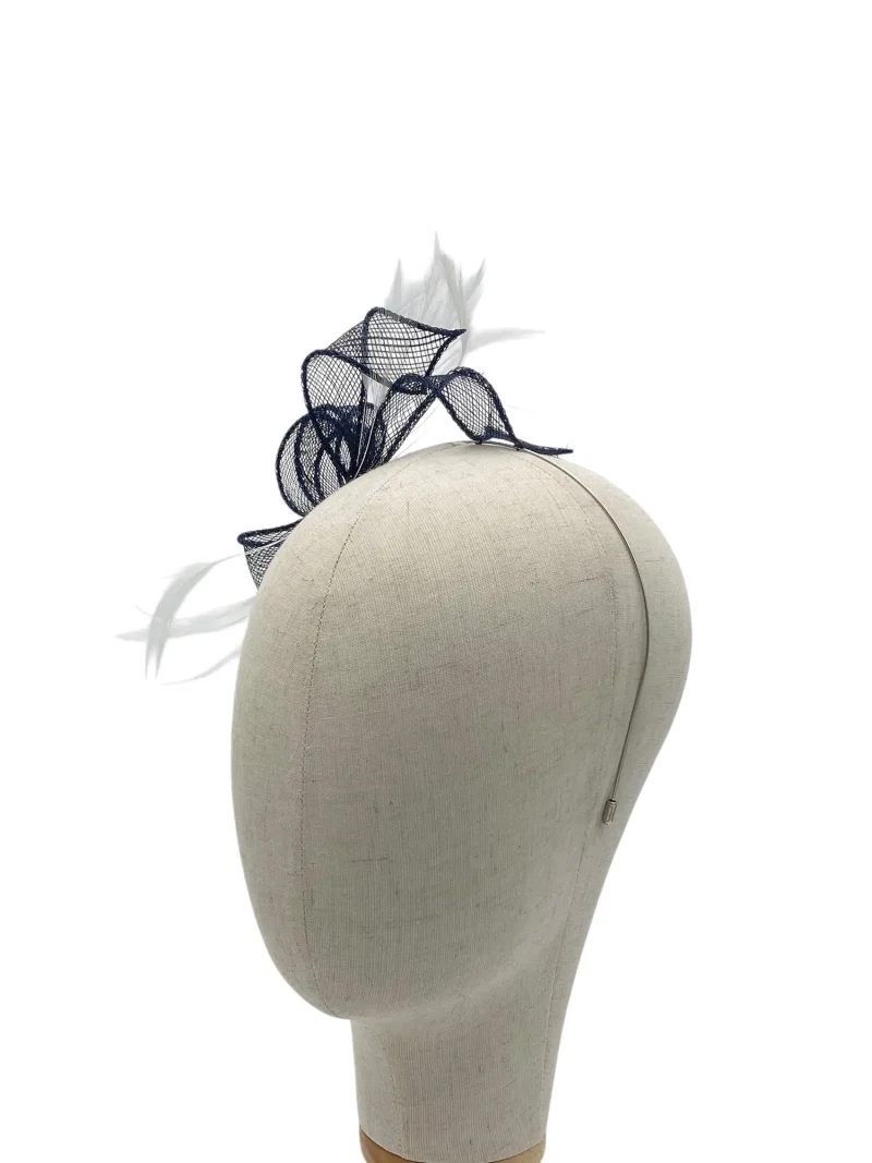 Beige mannequin head wearing a black mesh fascinator with feathers on top