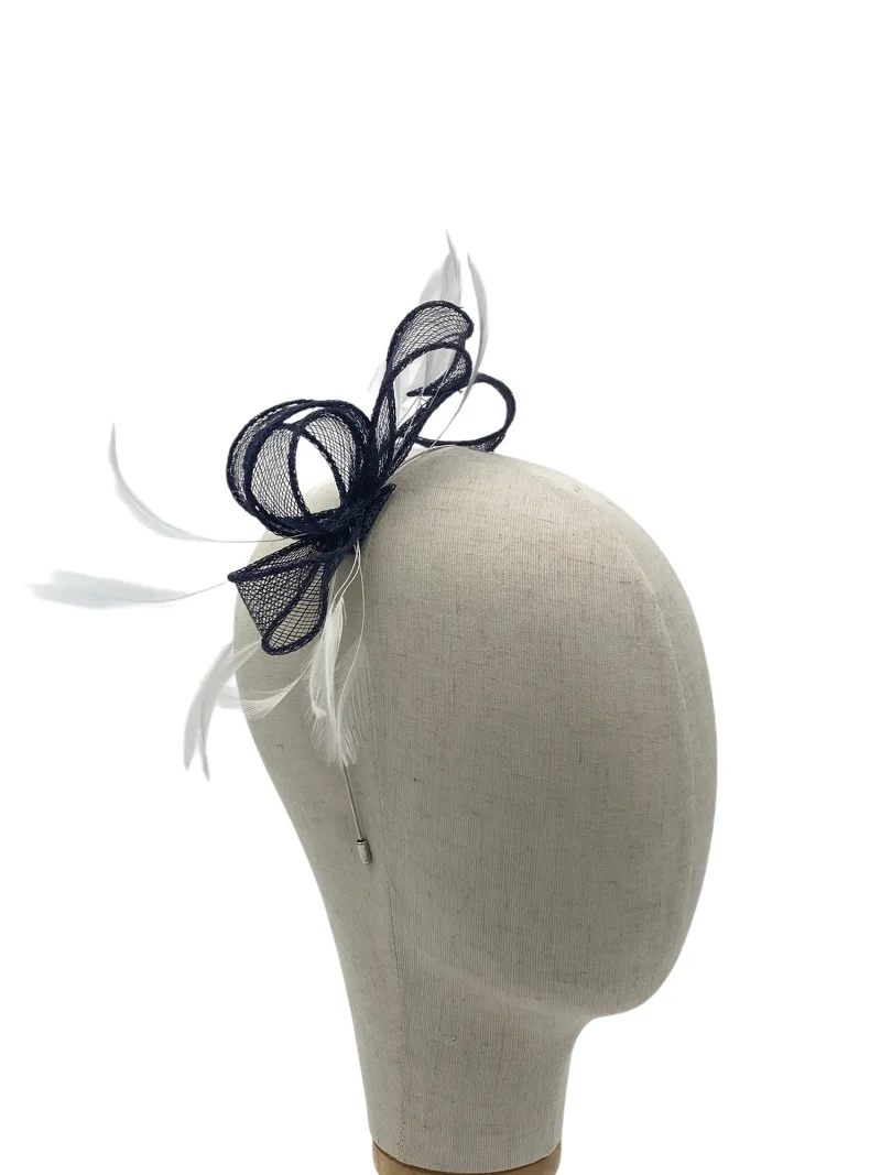 Navy fascinator with mesh loops and white feathers on a beige mannequin head. 94 chars
